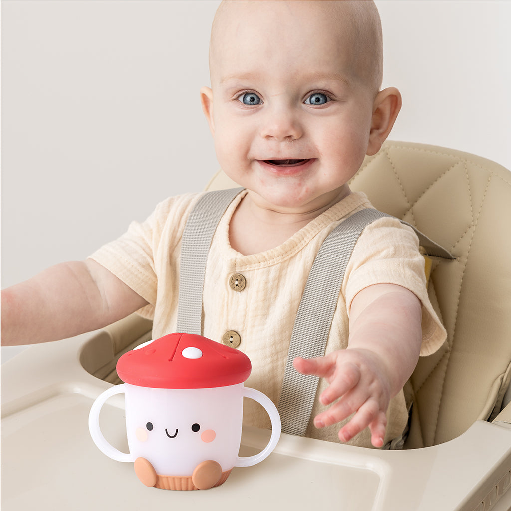 Baby sits in high chair with Itzy Ritzy Itzy Snack Cup - Ash the Mushroom