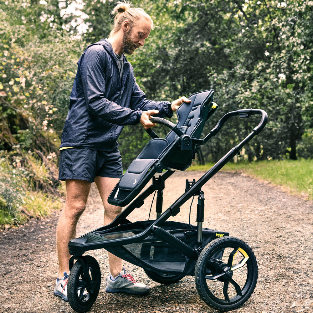 man attaches seat to Veer Switch&Jog Luxe Bundle - &Jog Jogging Frame