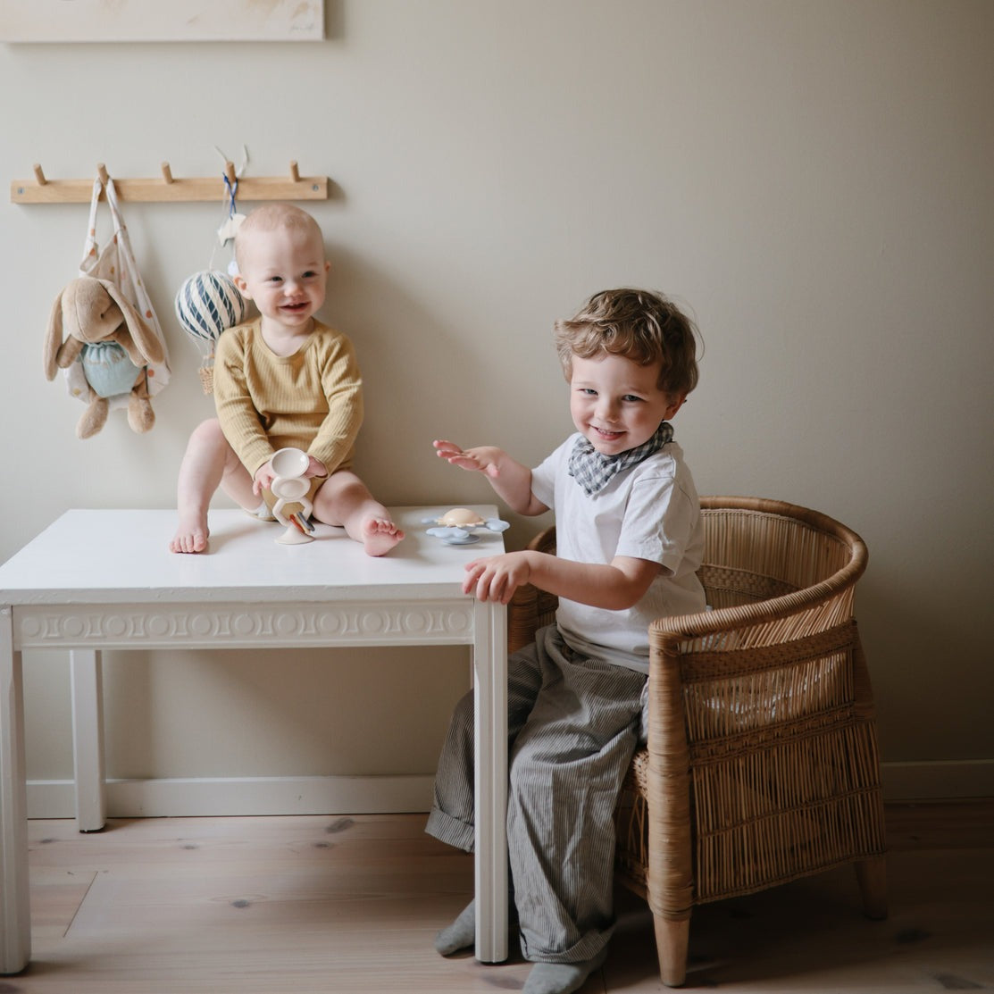 Siblings play with Mushie Hexapop Suction Toy - Shifting Sand