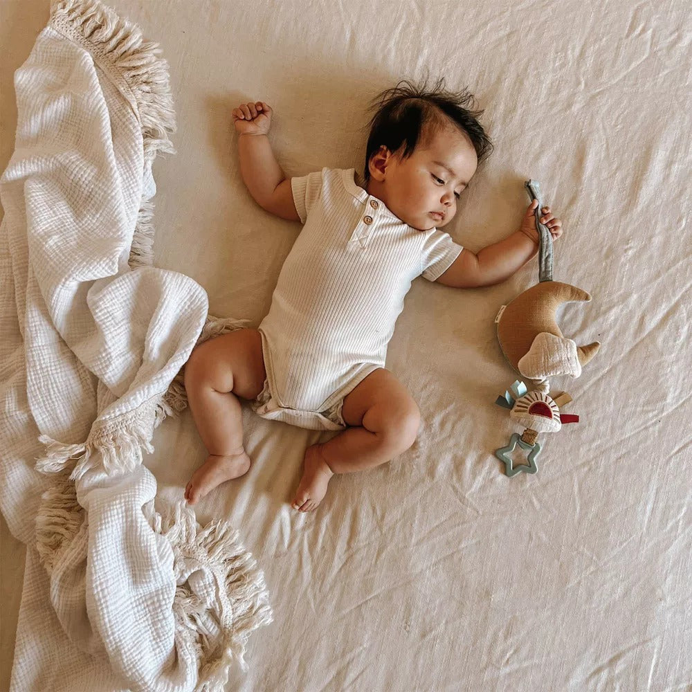 Baby sleeps while holding Itzy Ritzy Bitzy Notes - Musical Pull Down Toy - Cloud/Sun