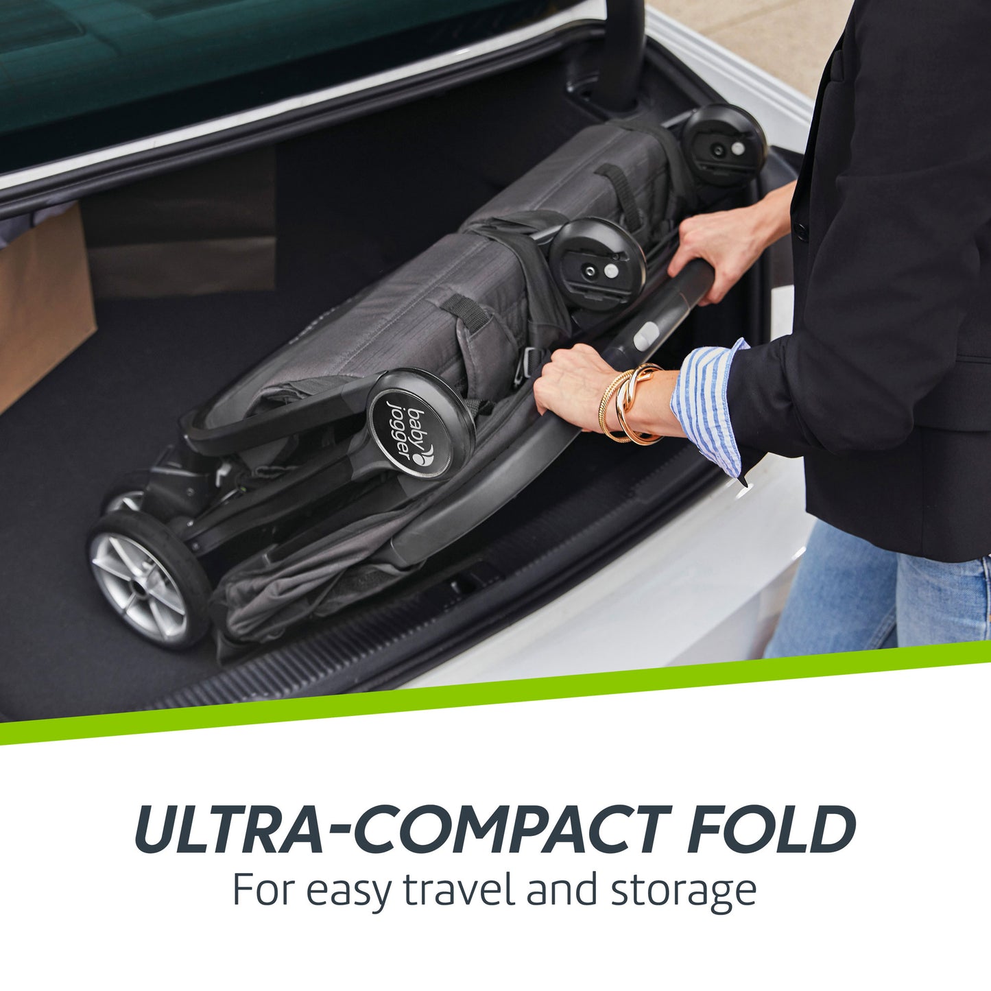 Woman puts folded Baby Jogger City Tour 2 Double Stroller in car trunk