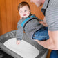 Dad laying toddler on Nuna SENA Aire Play Yard with Zip-Off Bassinet and Changer - Granite