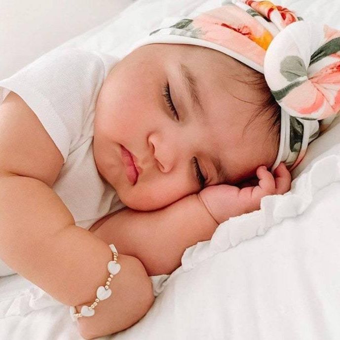 Baby wearing LittleLundsCo Baby Bracelet - White Heart