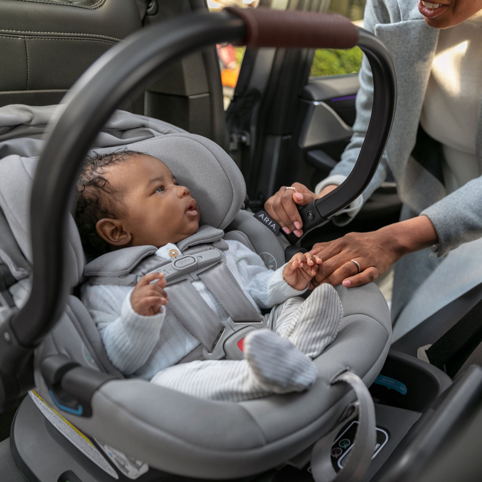 Mom puts baby in vehicle in UPPAbaby ARIA Infant Car Seat - ANTHONY (Light Grey)