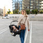 Woman carrying UPPAbaby ARIA Infant Car Seat - JAKE (Charcoal) in the city