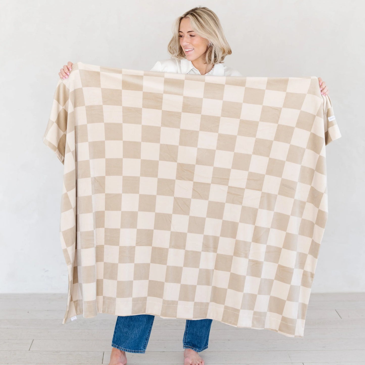 Woman holding Saranoni Minky Stretch Throw Blanket - Neutral Checkered
