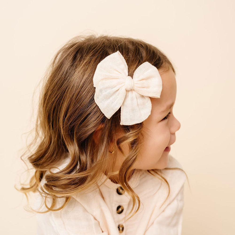 Little girl wearing Lou Lou and Company Cloud Muslin Heirloom Bow Clip - Cream