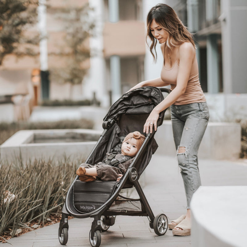 Mom pushes baby in Baby Jogger City Tour 2 Single Stroller