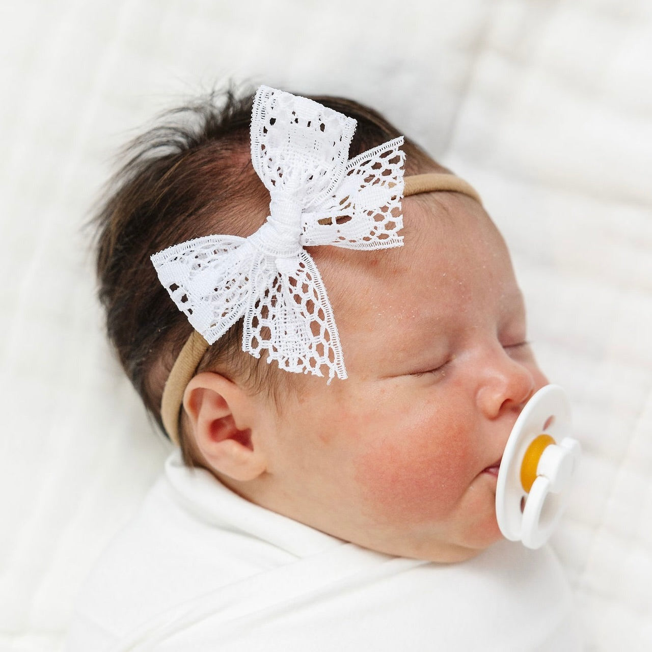 Newborn baby wearing Lou Lou and Company Lace Bow Headband - White