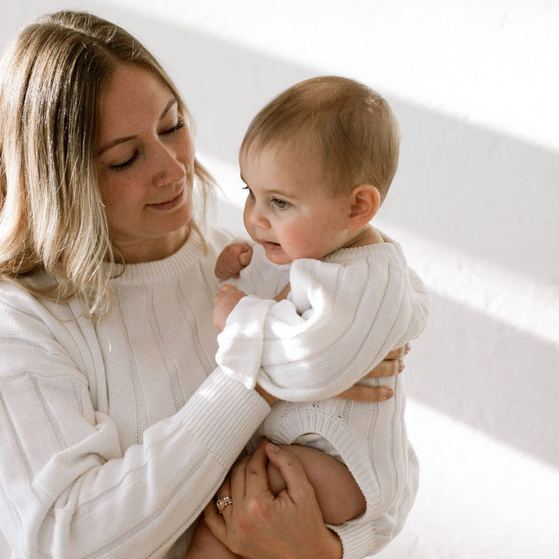 Mom holds baby wearing Oat and Co Wide Ribbed Knit Onesie - Dove