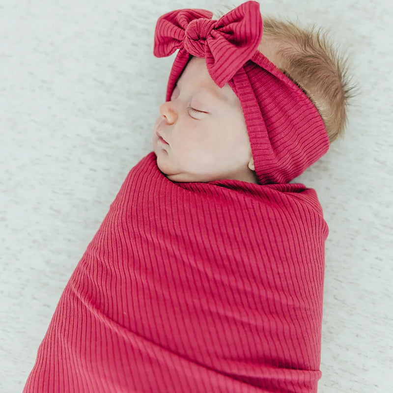 Baby wrapped in Copper Pearl Rib Knit Swaddle Blanket - Berry