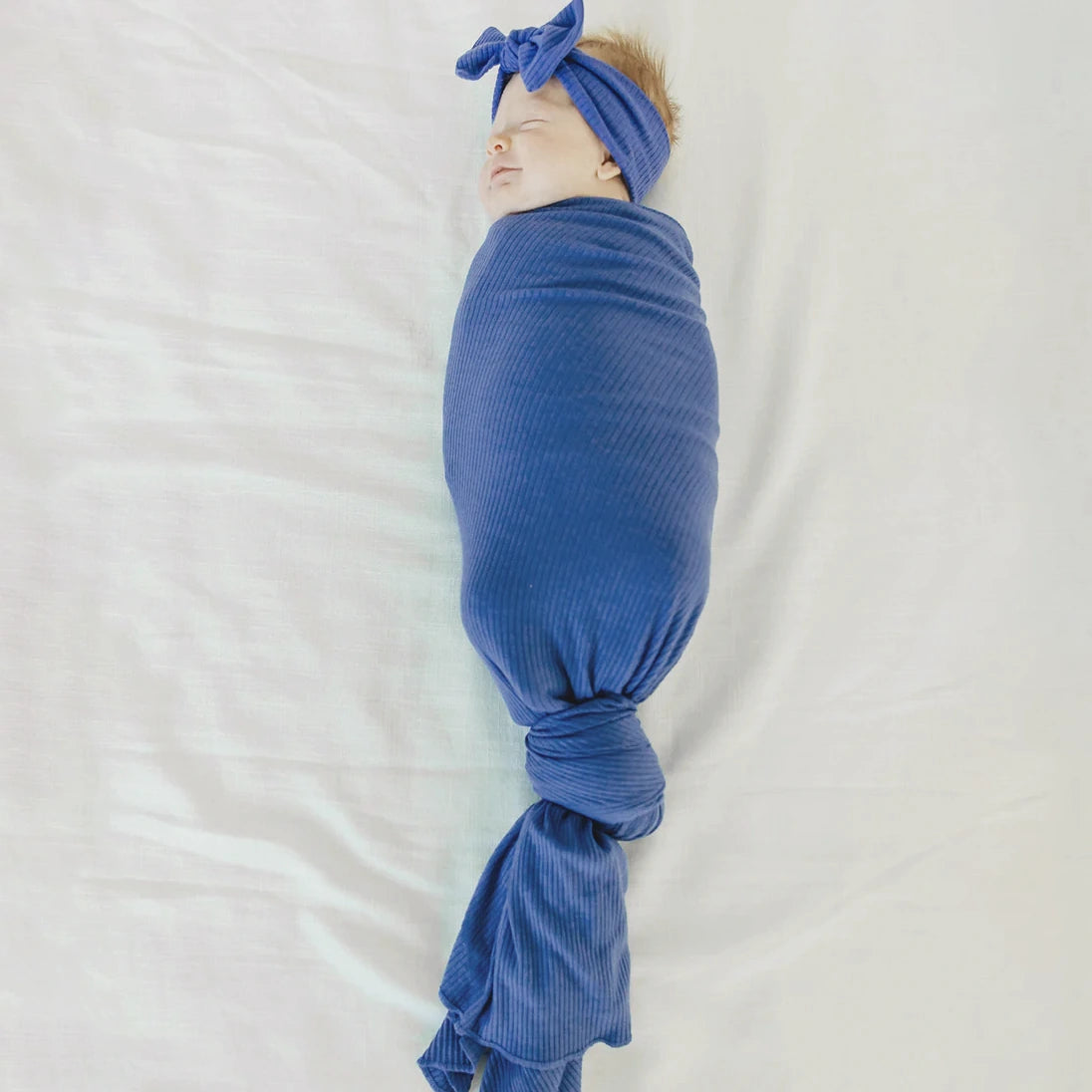 Baby wrapped in Copper Pearl Rib Knit Swaddle Blanket - Indigo