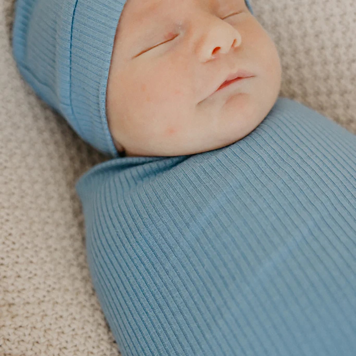 Baby wrapped in Copper Pearl Rib Knit Swaddle Blanket - Atlantic