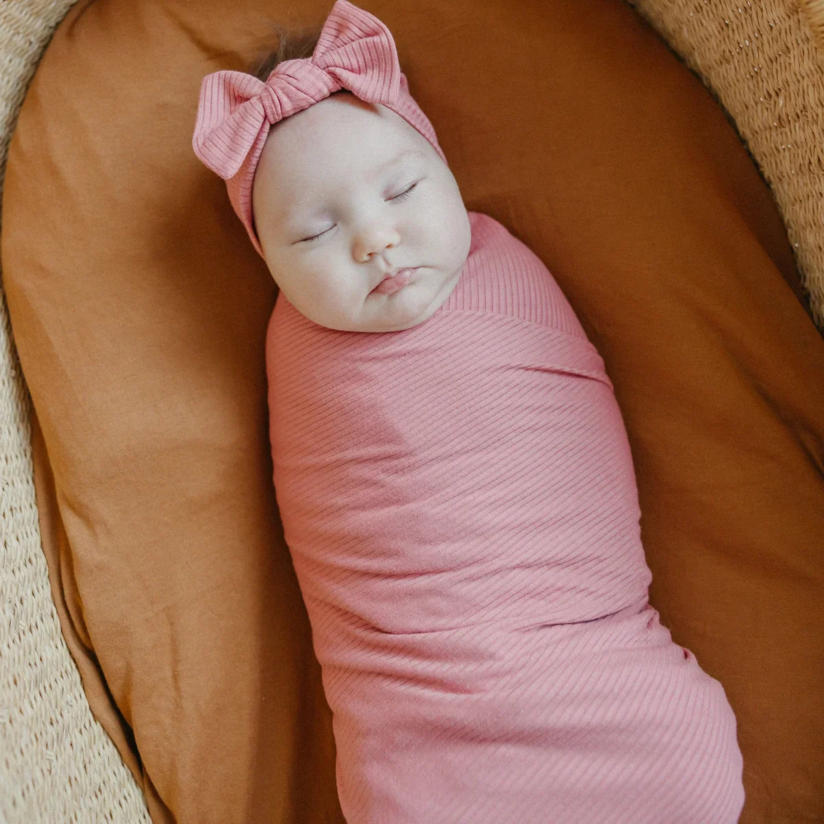 Baby wrapped in Copper Pearl Rib Knit Swaddle Blanket - Rosewood