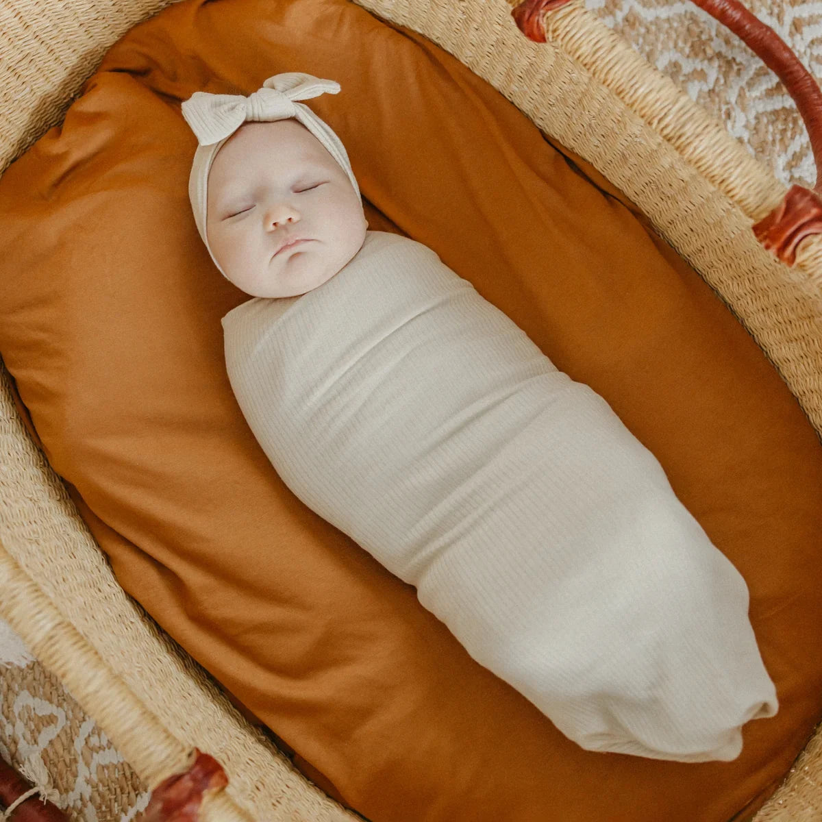 Baby wrapped in Copper Pearl Rib Knit Swaddle Blanket - Moonstone