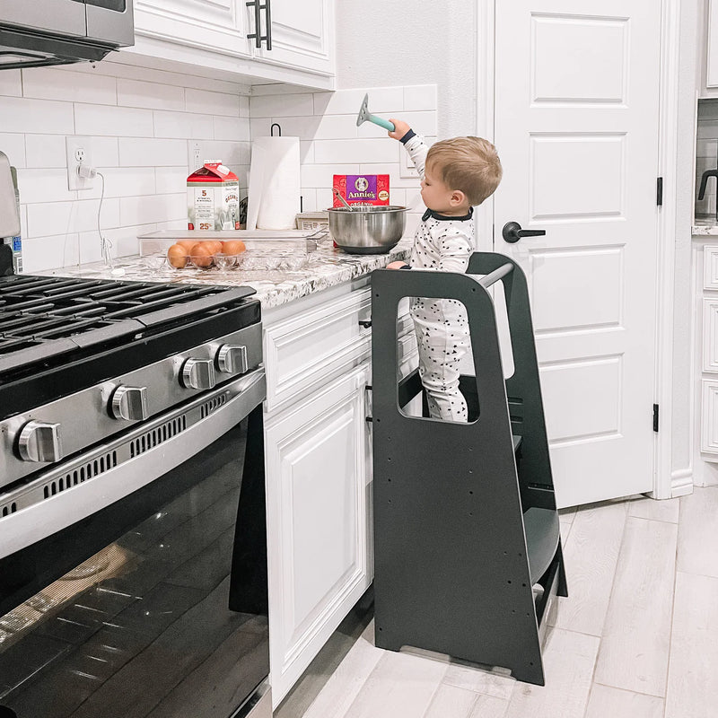 Boy cooking in kitchen while standing on Dadada Toddler Tower - Graphite