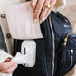 Mom pulling wipes out of side of JuJuBe Satchel - Black