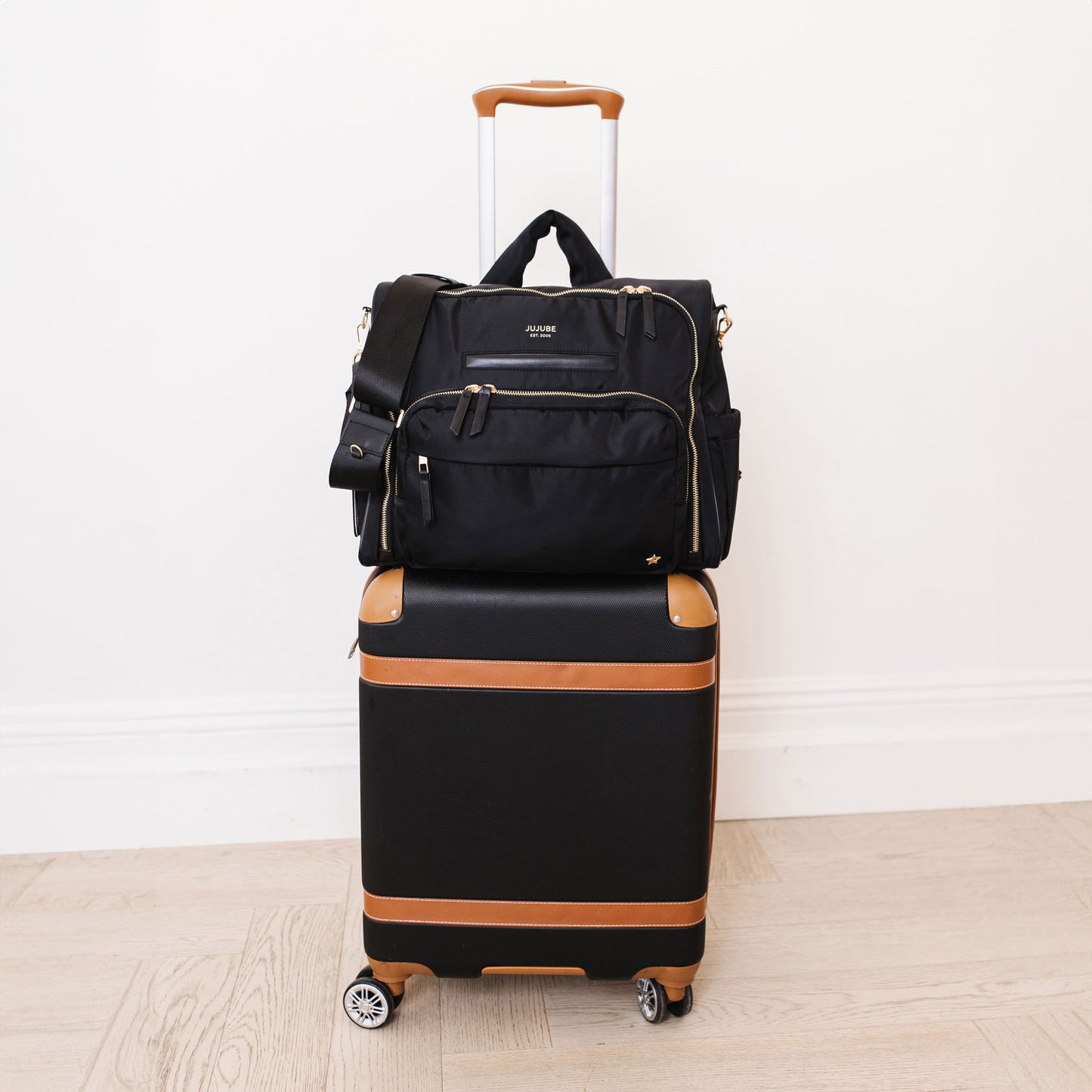 JuJuBe Satchel - Black on a suitcase