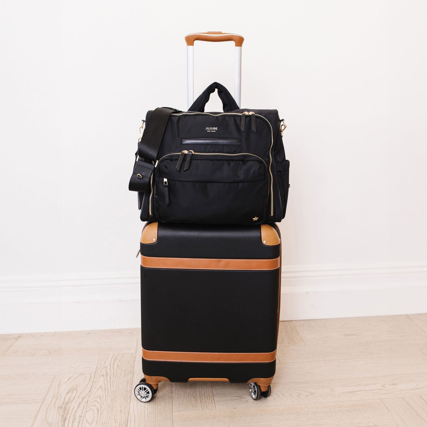 JuJuBe Satchel - Black on a suitcase