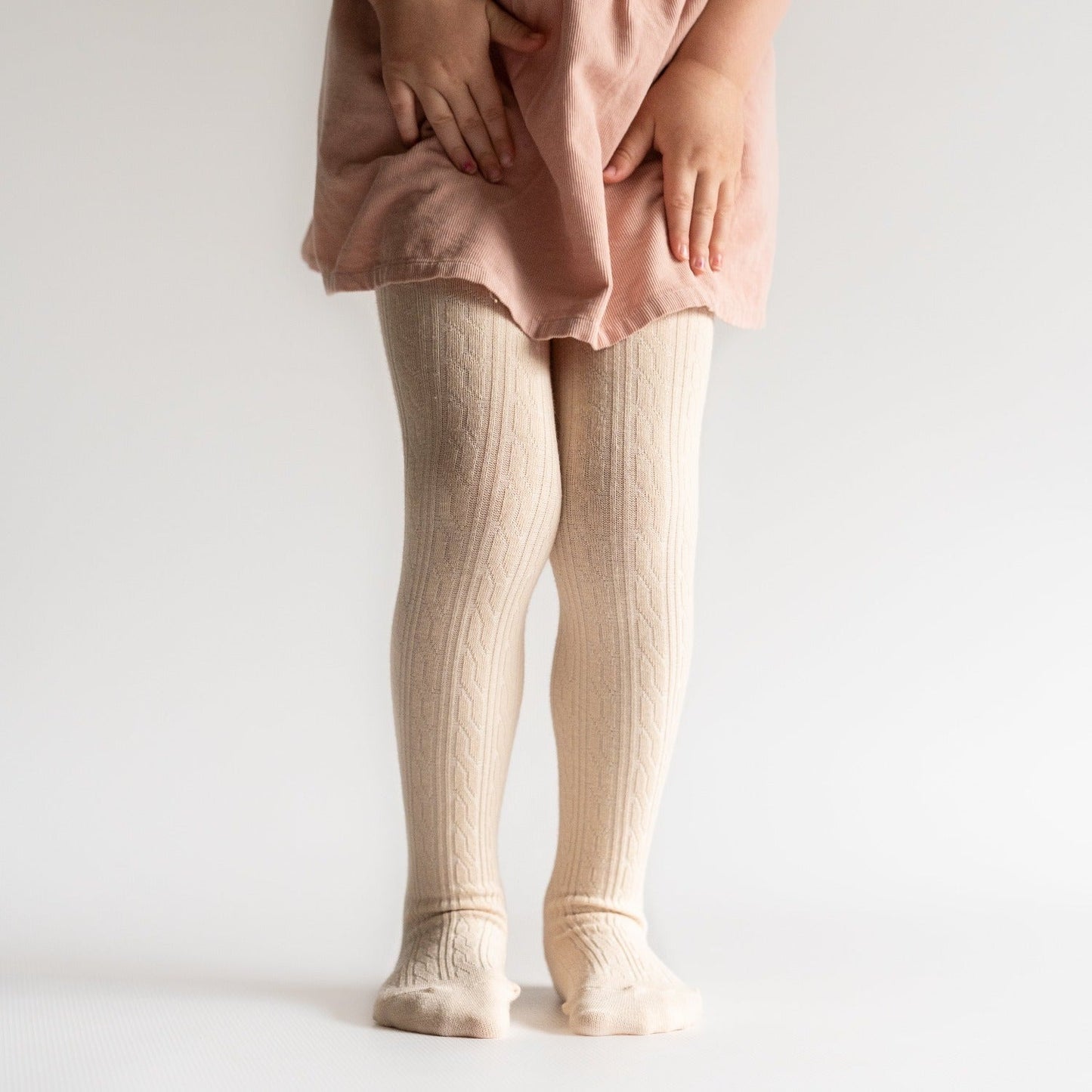 Little girl wearing Little Stocking Co Cable Knit Tights - Vanilla