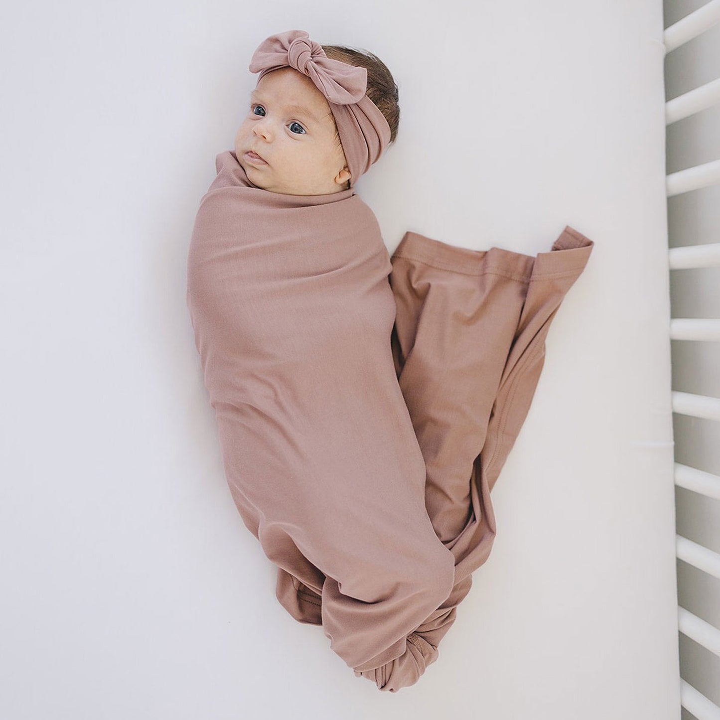 Baby swaddled in Mebie Baby Bamboo Stretch Swaddle Blanket - Dusty Rose