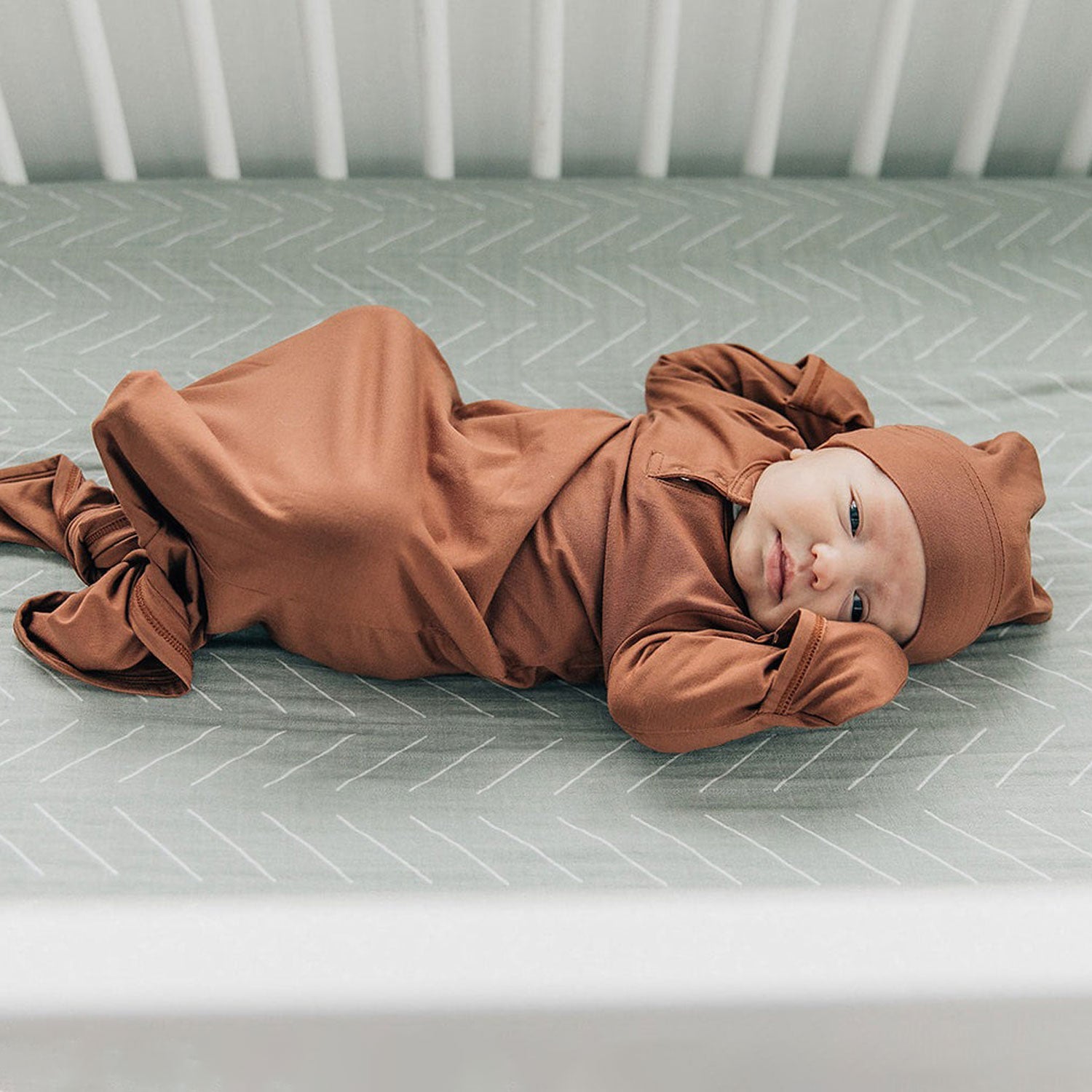 Baby lying on Mebie Baby Crib Sheet - Desert Sage