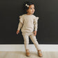 Little girl wearing Mebie Baby Knit Ruffle Sweater - Oatmeal