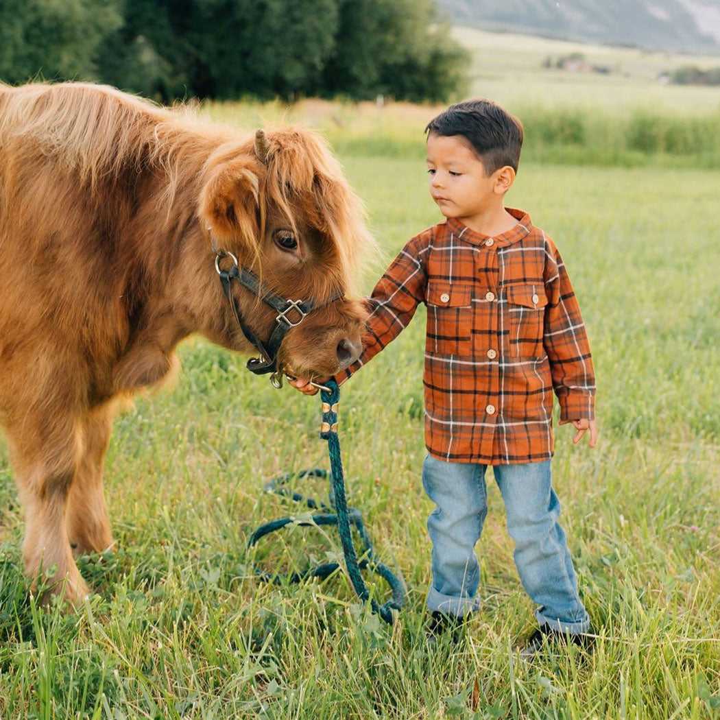Little boy petting cow while wearing Mebie Baby Shacket - Fall Plaid - Orange