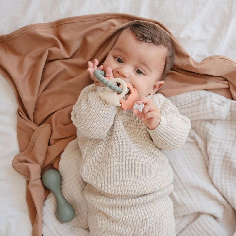 Baby chewing on Mushie Teething Ring - Dino