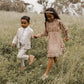 Girl wearing Noralee Mirabelle Dress - Autumn Garden runs through field with boy