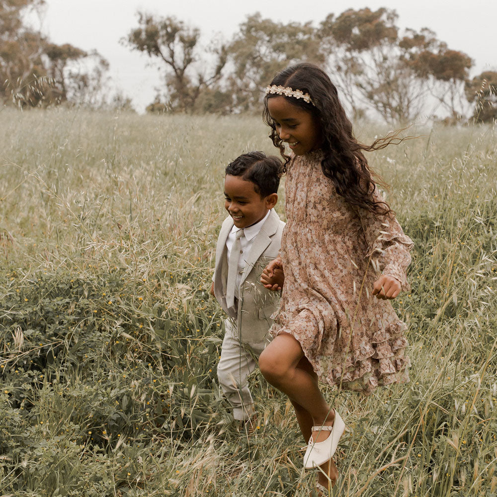 Girl wearing Noralee Mirabelle Dress - Autumn Garden runs through field with boy
