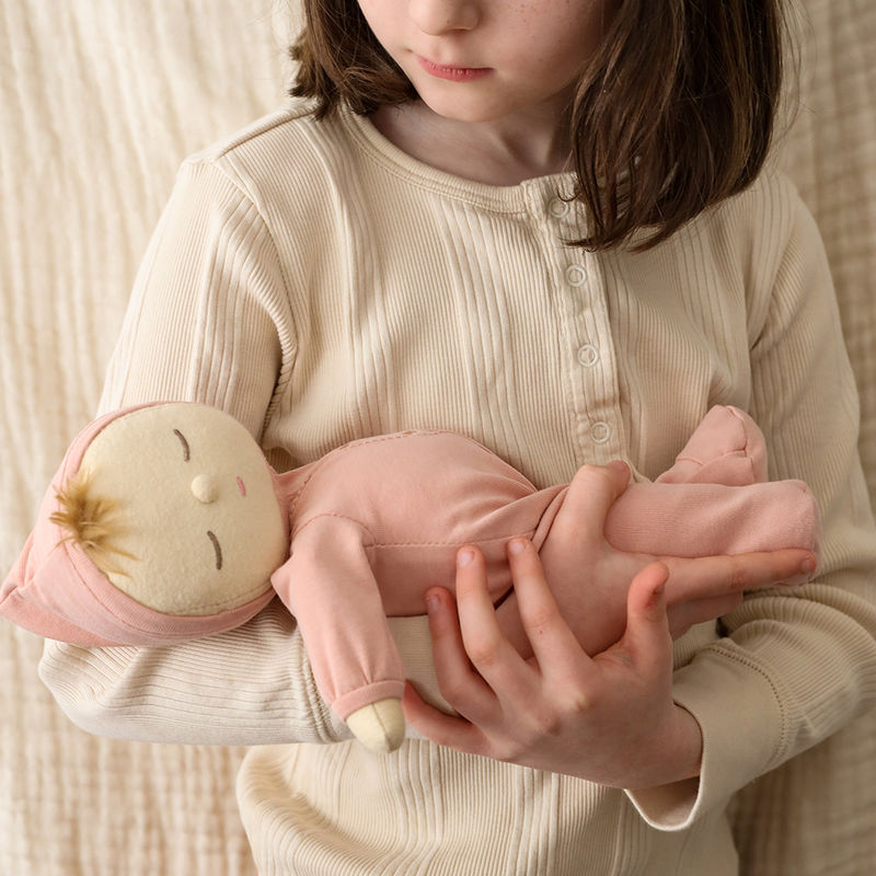 Girl cradling Olli Ella Dozy Dinkum Doll - Moppet