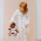 Little girl playing with Olli Ella Dinkum Dolls Travel Togs - Outfit Set - Prairie Floral