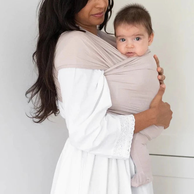 Woman wearing baby in Solly Baby Wrap - Petal