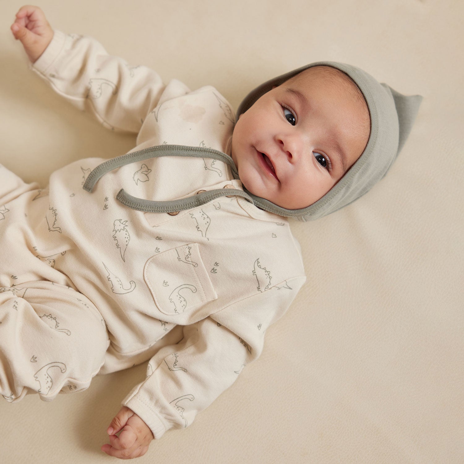 Baby wearing Quincy Mae Long Sleeve Jumpsuit - Dino - Natural