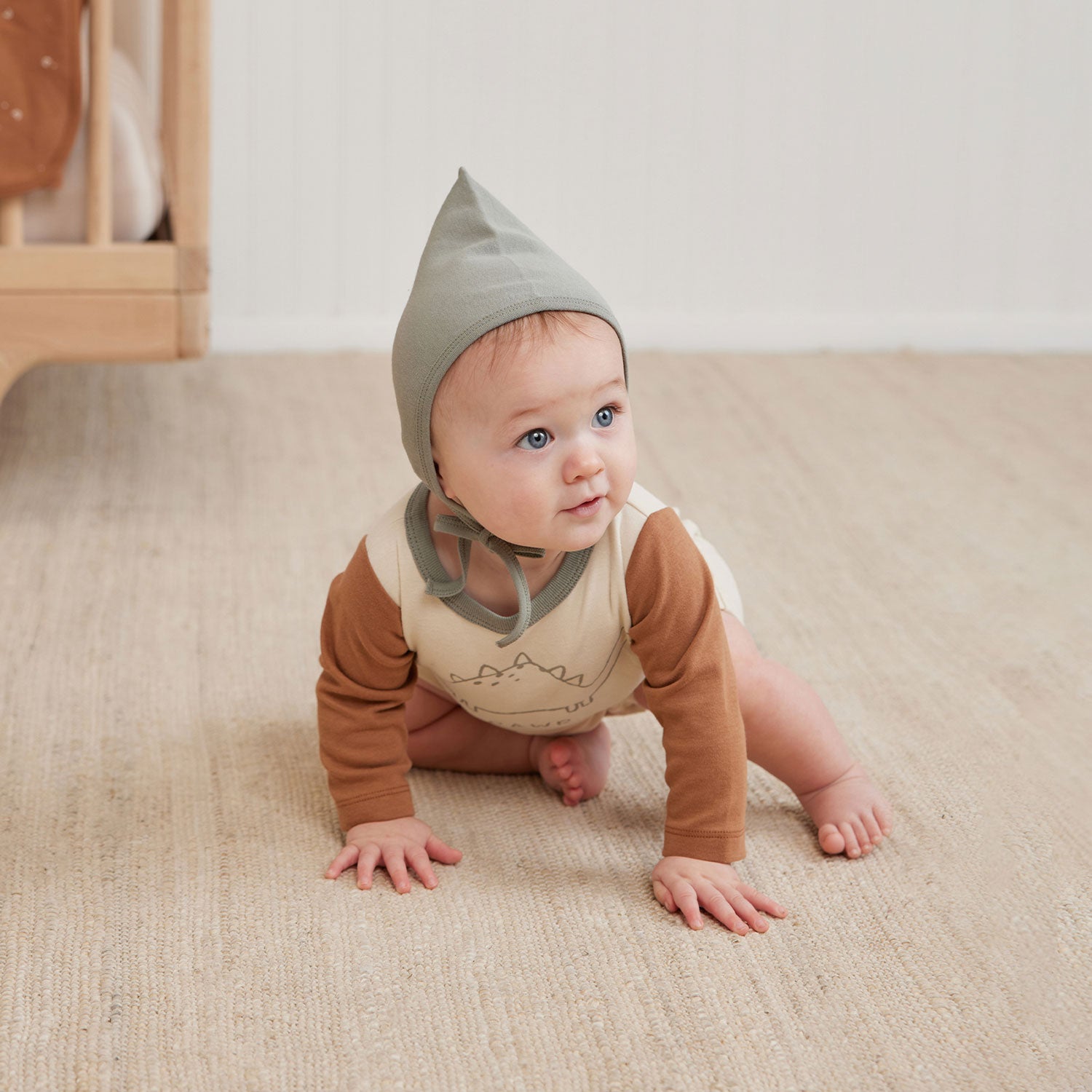 Baby wearing Quincy Mae Long Sleeve Romper - Dino - Natural