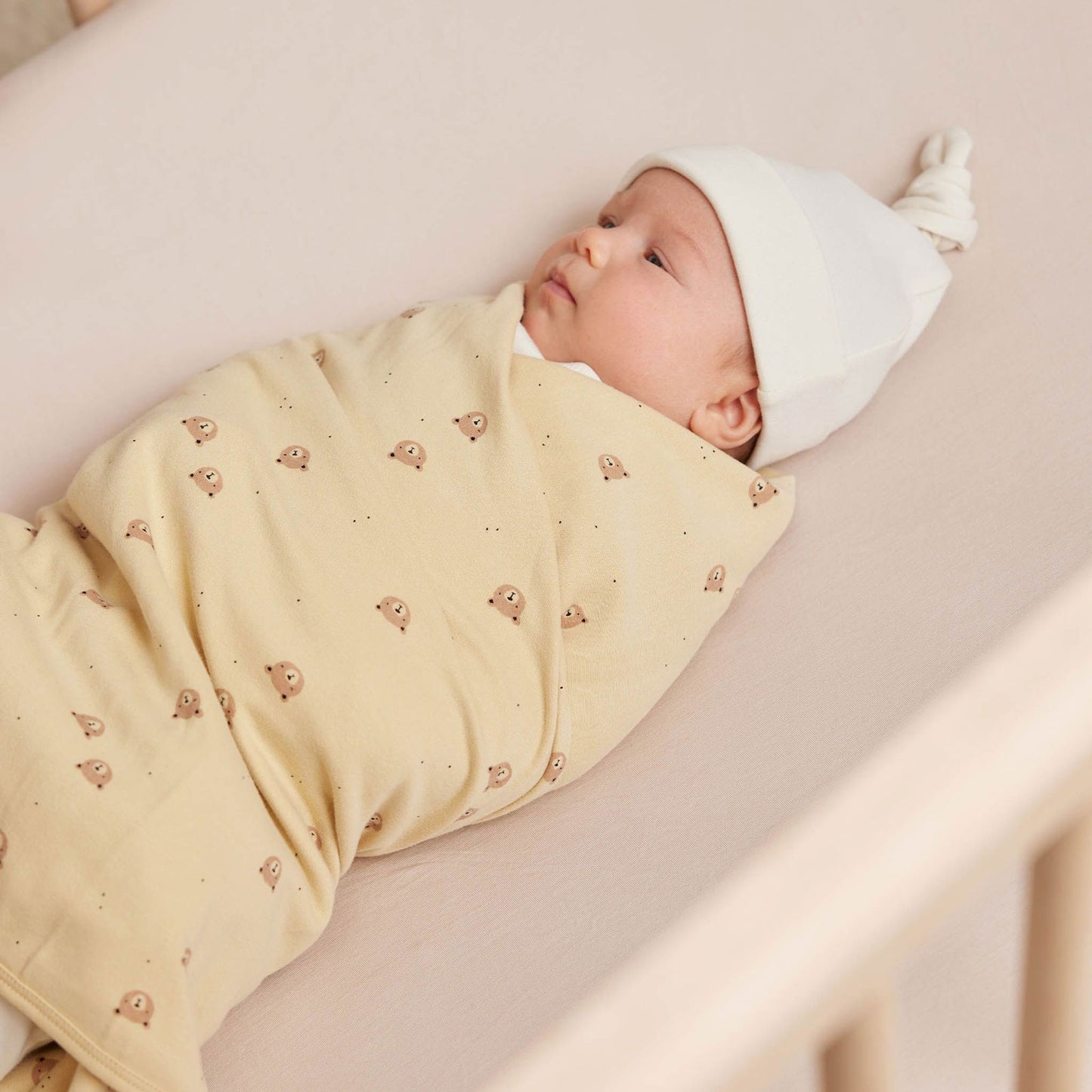 Baby wrapped in Quincy Mae Baby Swaddle Blanket - Bears - Butter