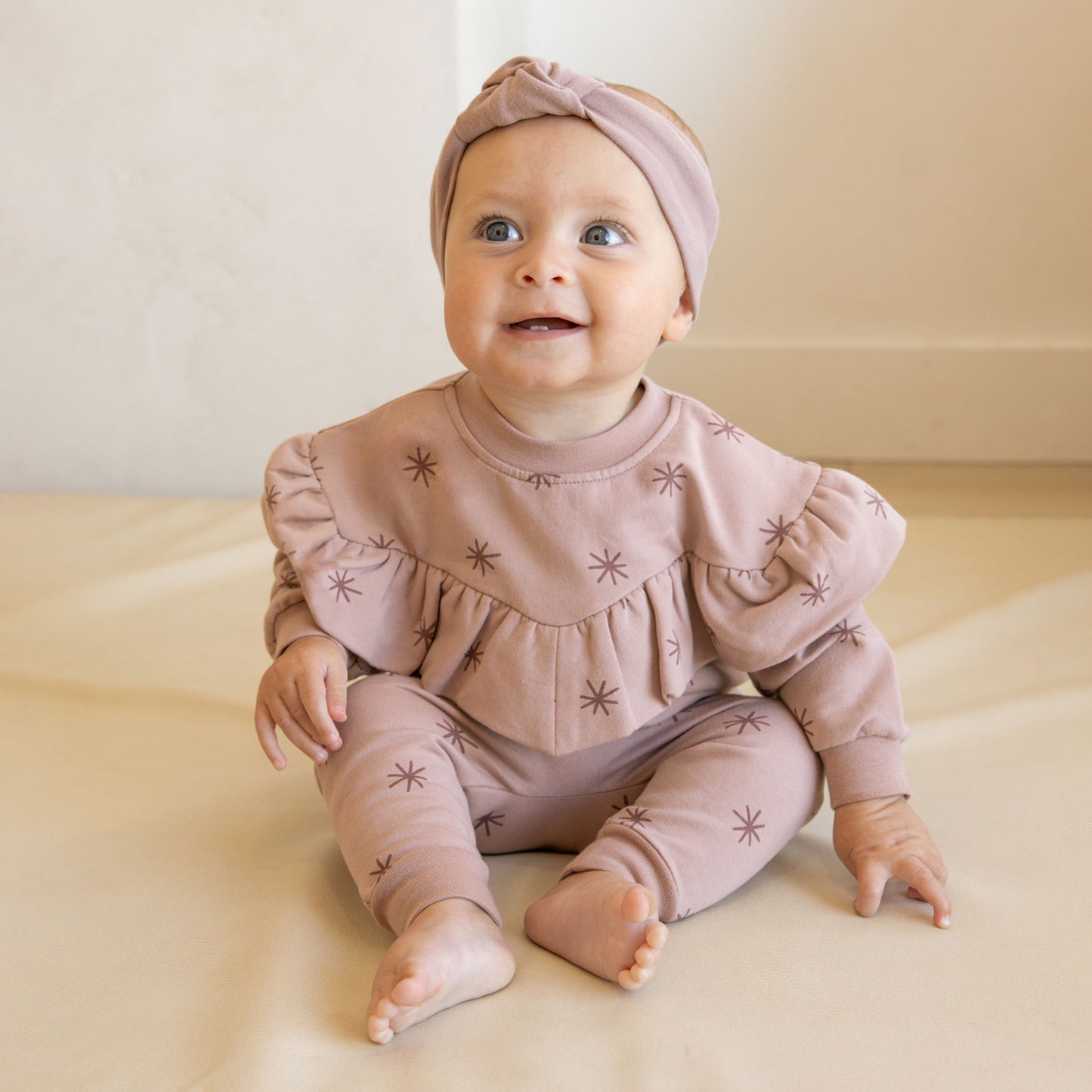 Baby wearing Quincy Mae Fleece Sweatpant - Snow Stars - Mauve
