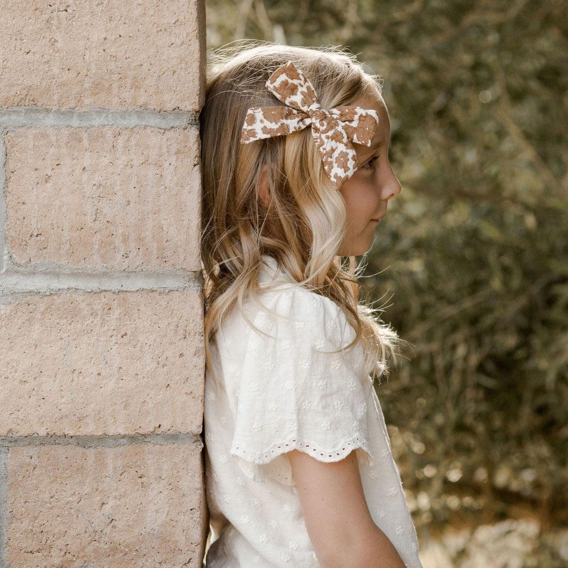 Girl wearing Rylee and Cru Girl Bow Clip - Gold Gardens