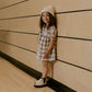 Girl holding book wearing Rylee and Cru Maxwell Dress - French Blue Flannel