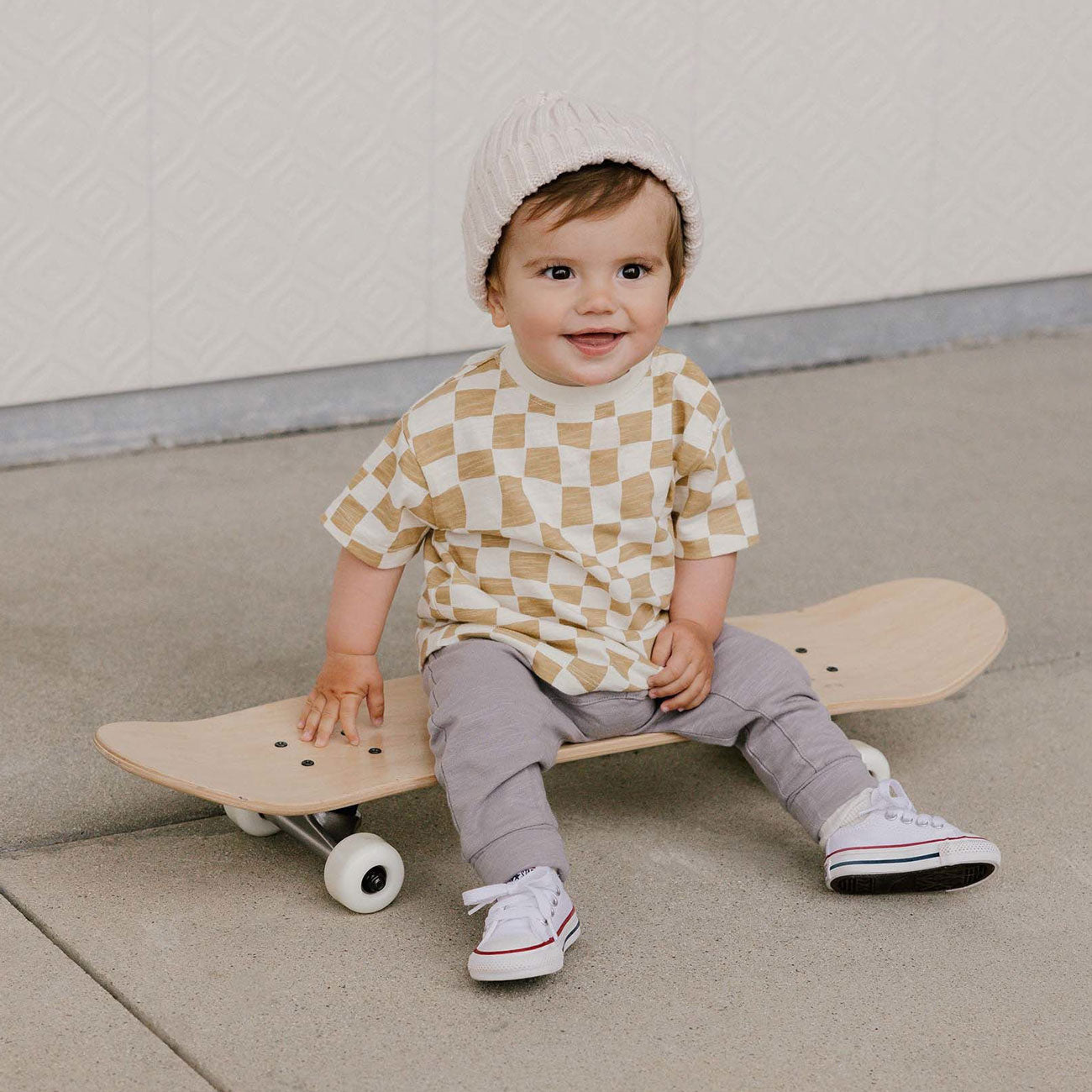 Boy sitting on skateboard wearing Rylee and Cru Relaxed Tee - Sand Check