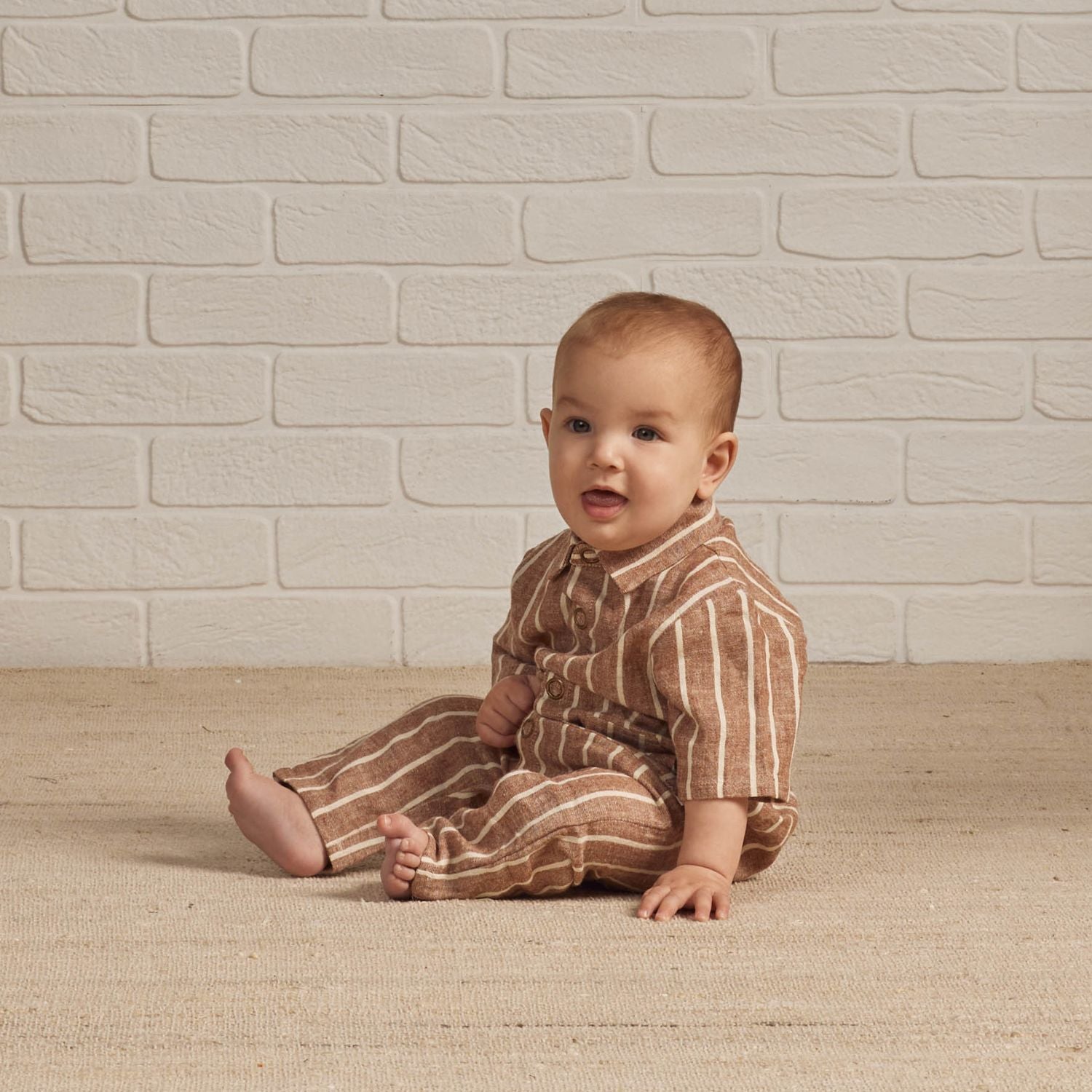 Baby wearing Rylee and Cru Rhett Jumpsuit - Cedar Pinstripe
