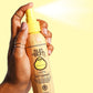 Adult spraying Sun Bum Revitalizing 3 in 1 Leave In Conditioner