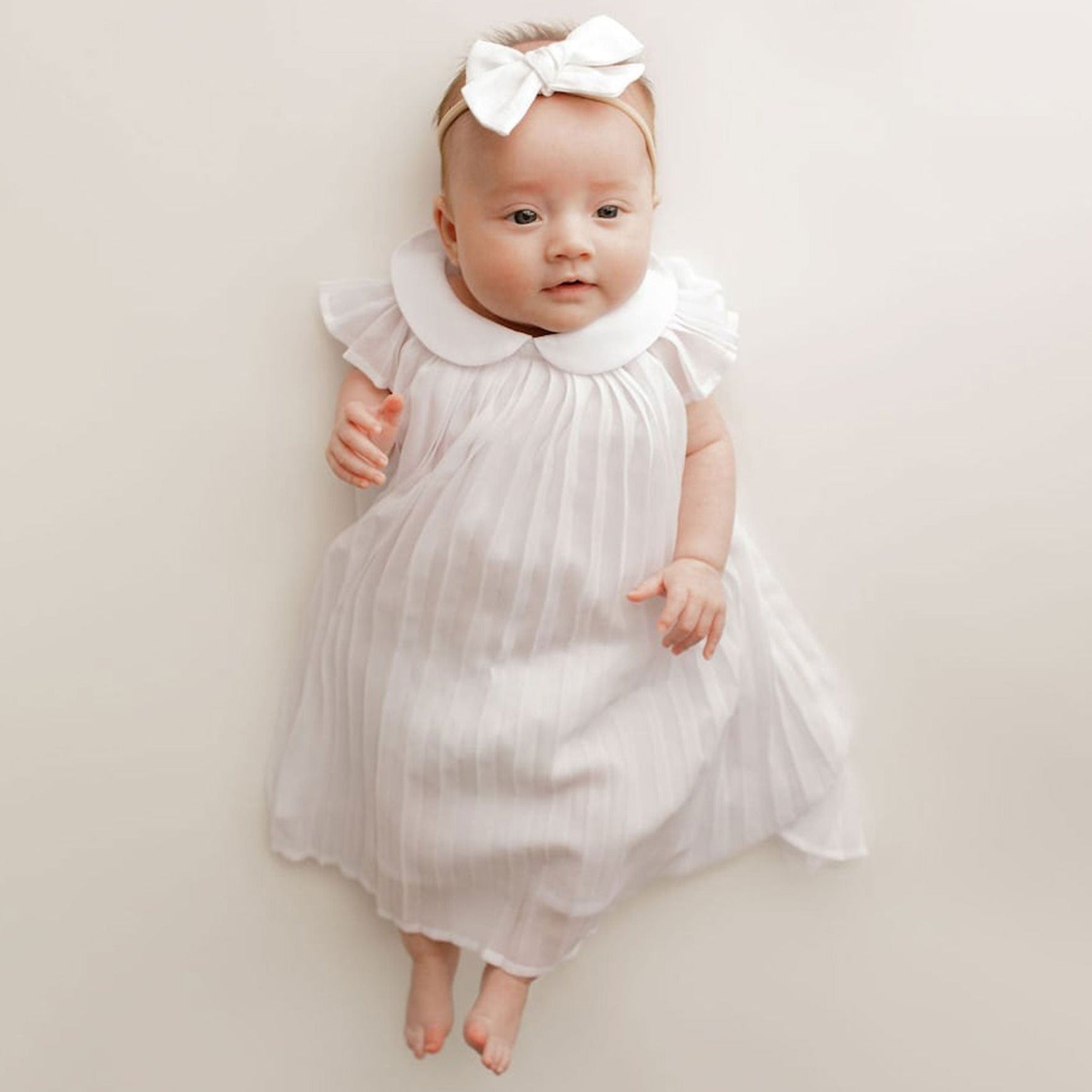 Baby wearing Chloe and Boone Ellie Blessing Gown