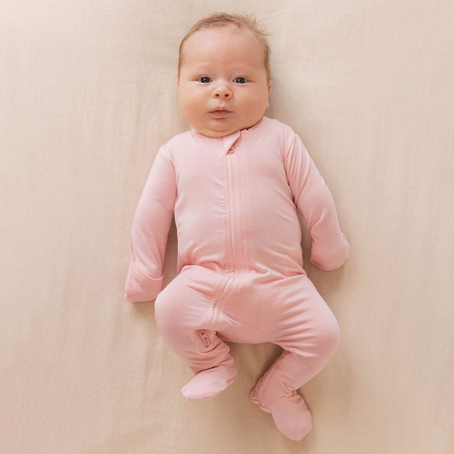 Baby wearing WildBird CloudBlend™ Footed Pajamas - Galah - 0-3M