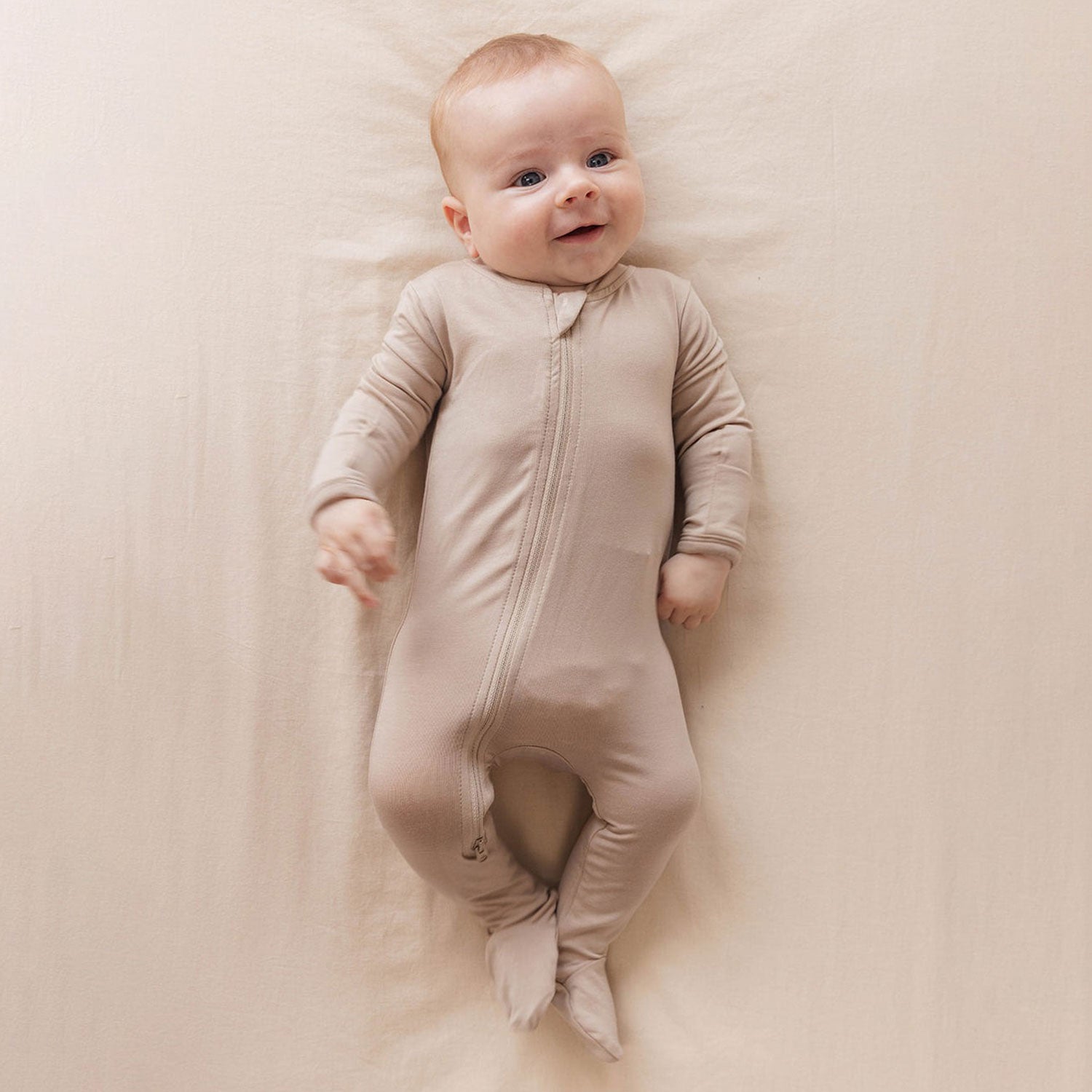 Baby wearing WildBird CloudBlend™ Footed Pajamas - Desert Lark - 0-3M