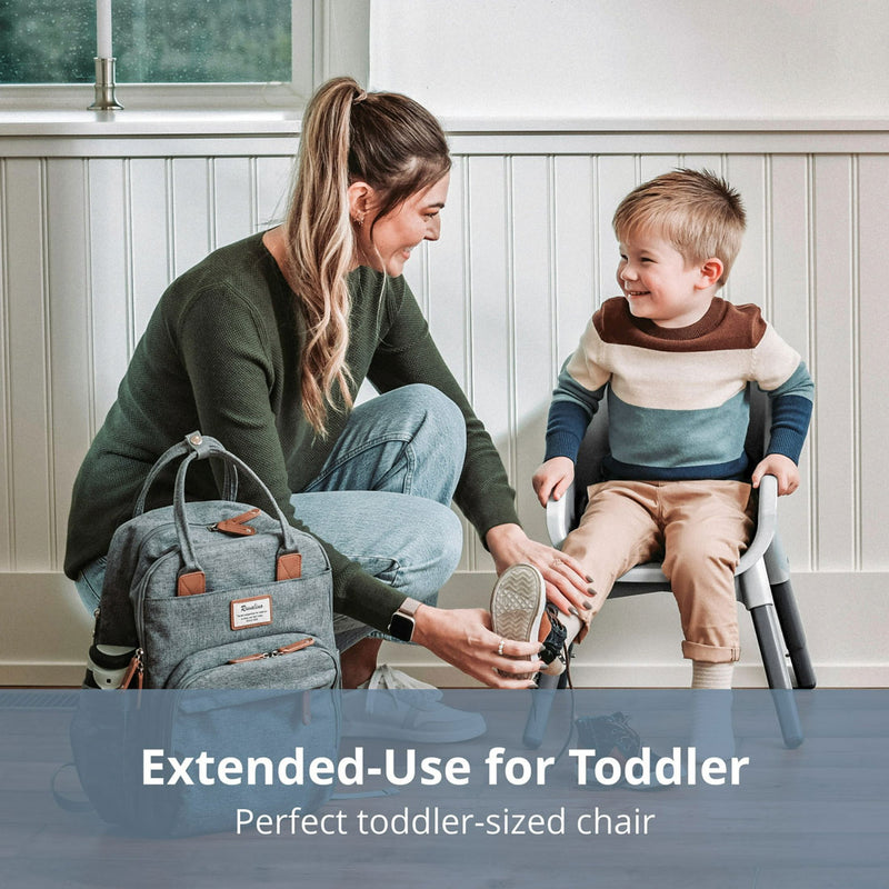 Mom puts shoes on little boy while he sits in Chicco Zest 4-in-1 Folding High Chair - Seasalt in stool mode