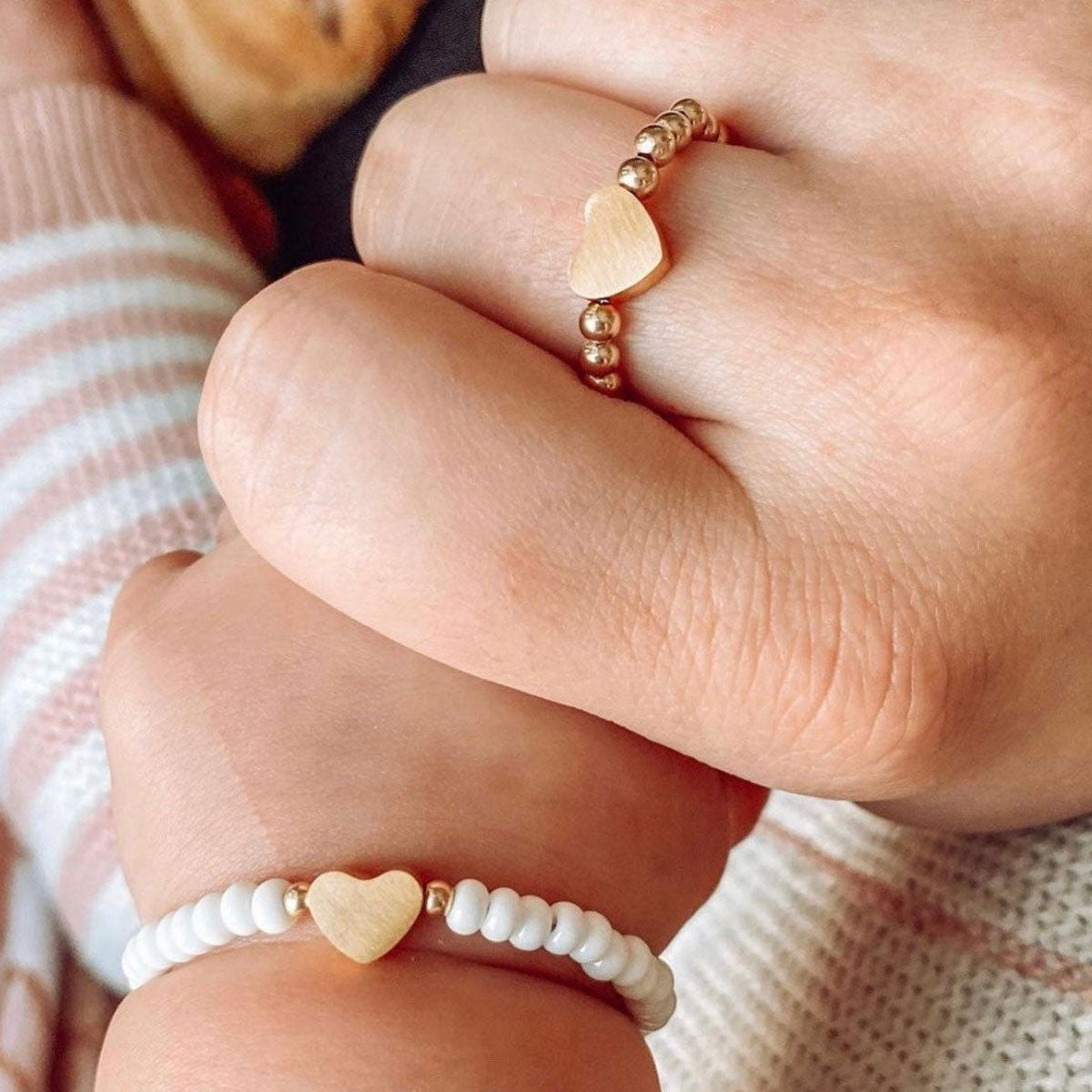 Baby holds mom's hand while wearing LittleLundsCo Baby Bracelet - Heart of Gold