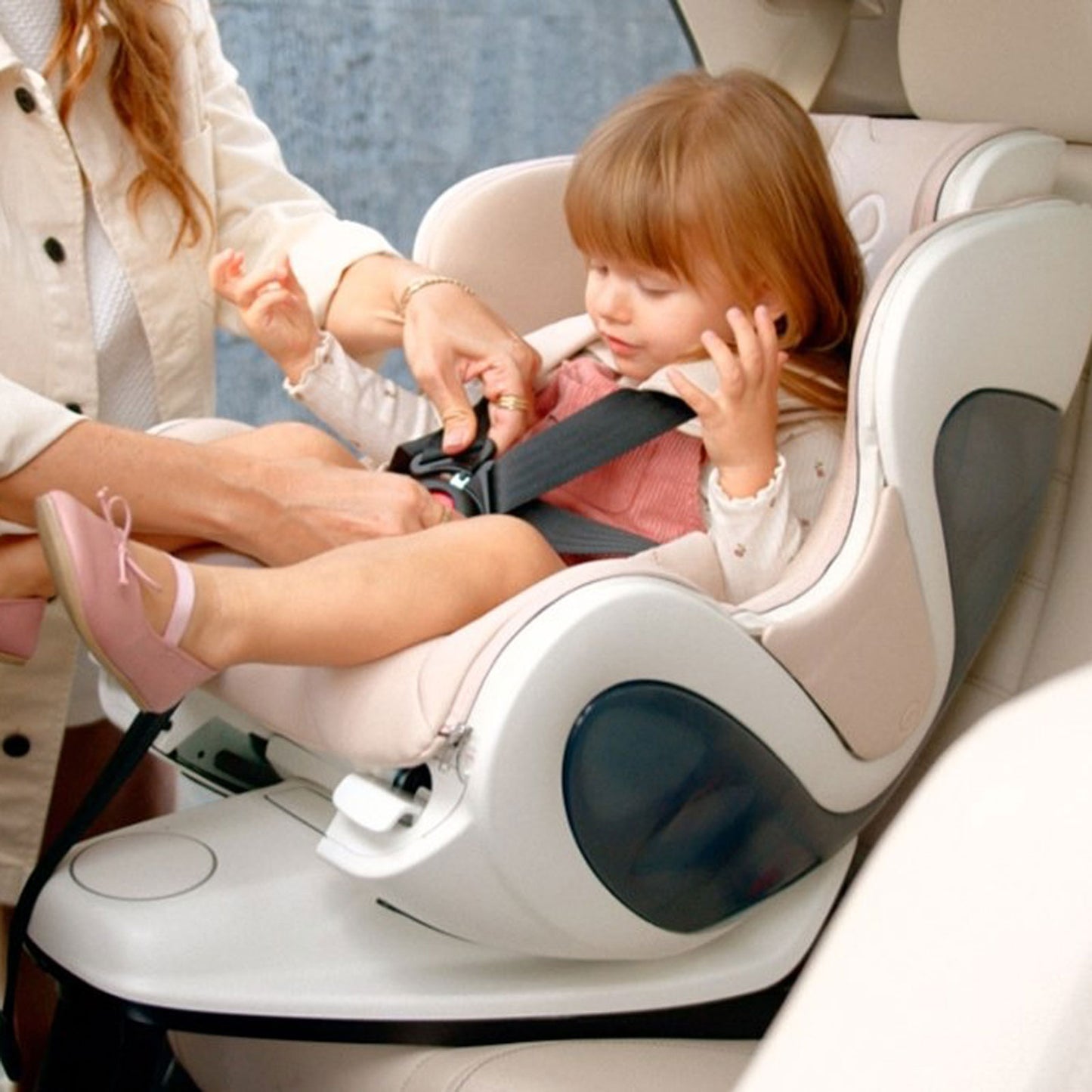 Mom buckling toddler into babyark Convertible Car Seat + Base - Moonlight Seat / Eggshell Base
