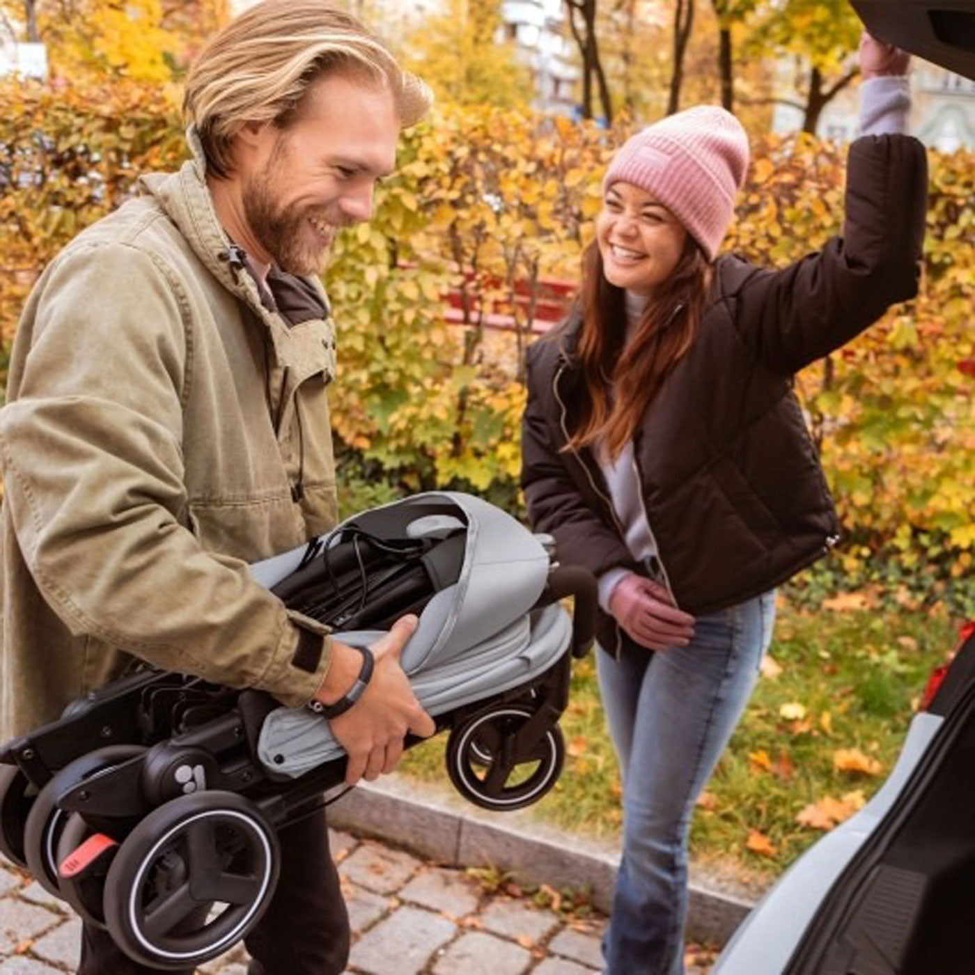 Dad putting Maxi-Cosi Mara XT Ultra Compact Stroller - Essential Black into car